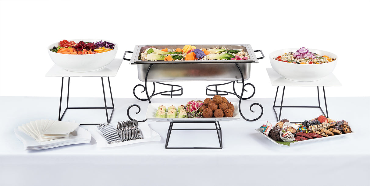 A buffet table with several Middle Eastern Themed Menu selections on it.