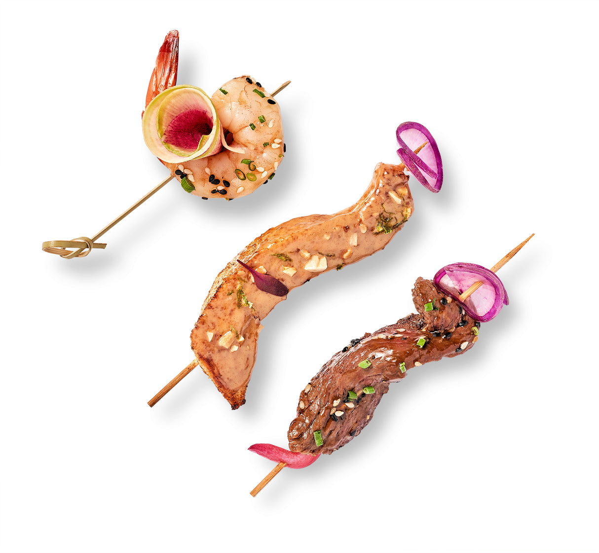 Three Skewers Trio on a white background featuring rosemary balsamic beef.