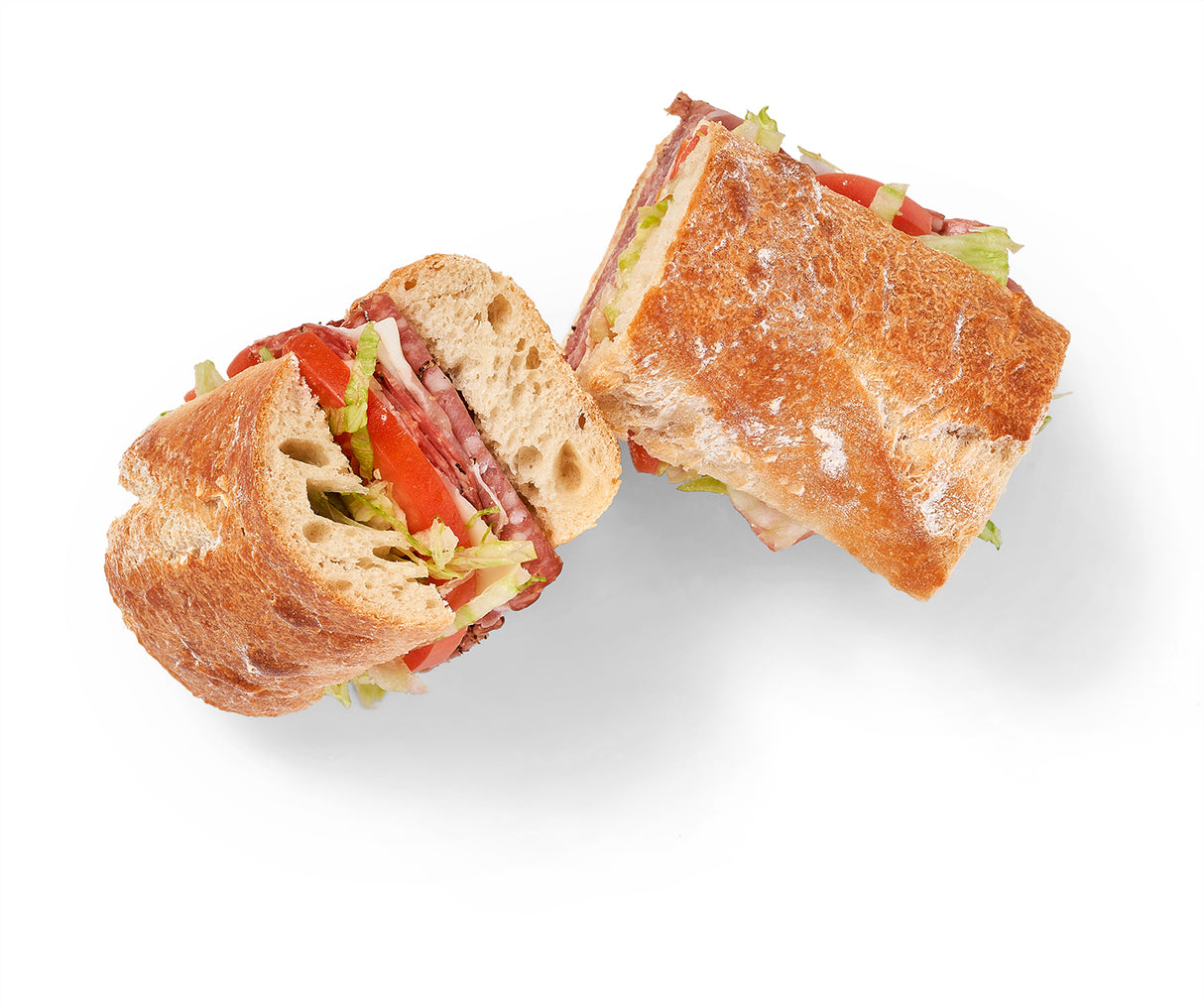 Two Classic Italian Sandwiches with salami and prosciutto, cut in half on a white background.