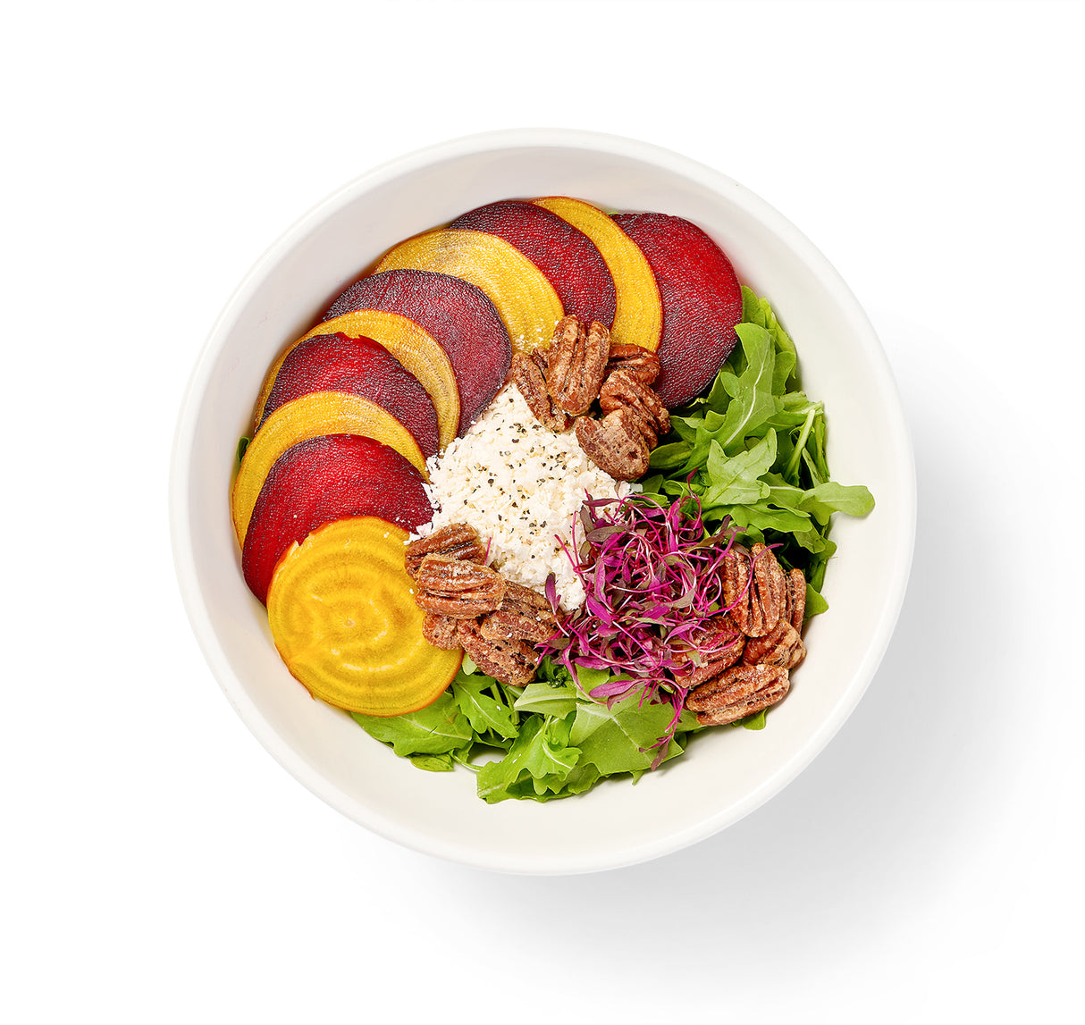 An Arugula-Beet Salad with sliced beets and pecans in it.