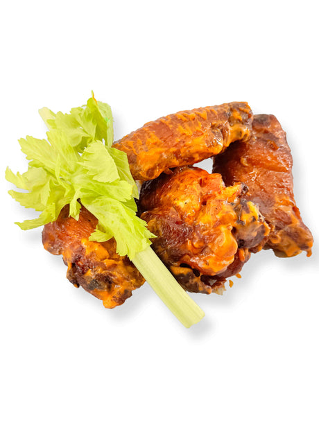 Traditional Buffalo Wings served with celery sticks and a drizzle of blue cheese dressing, all against a pristine white background.