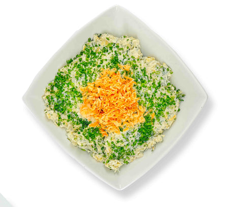 A square bowl filled with Spinach Artichoke Dip, topped with green herbs and a heap of shredded Parmesan in the center, invites appetites. The artichokes add depth to this creamy delight.