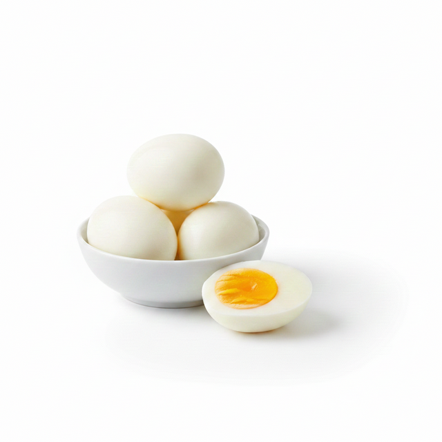 A small white bowl of Hard Boiled Eggs, including four eggs with one sliced in half to reveal the yellow yolk, displayed on a white background.