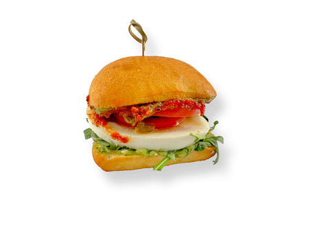 Enjoy a Vegetarian Mini Sandwich with basil pesto aioli, mozzarella, confit summer tomatoes, and fresh greens on homemade focaccia, all held together with a toothpick.