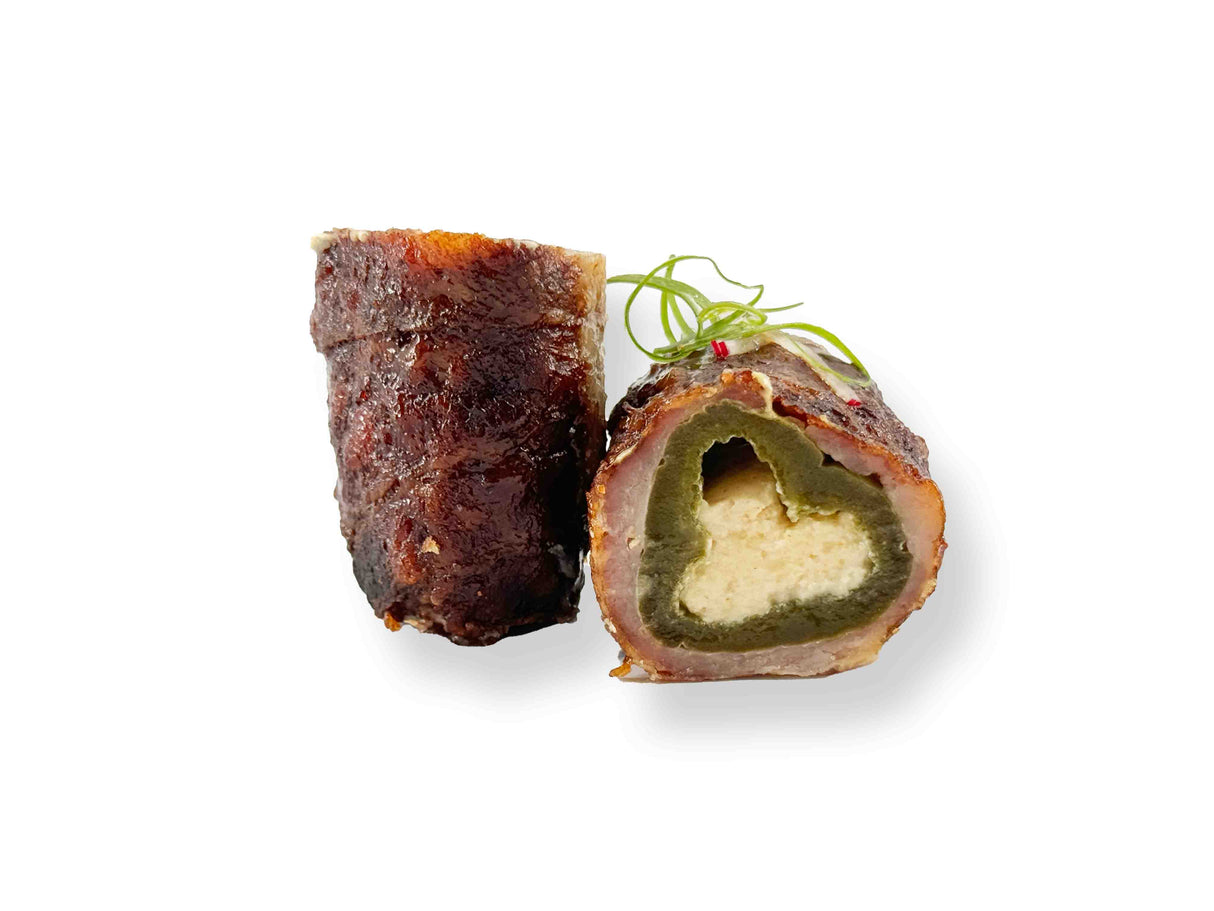 Two slices of Jalapeno Poppers, one cut open to show cream cheese and Pepper Jack filling, garnished with green onion on a white background.