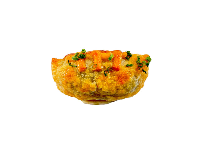 Golden-brown Philly Cheesesteak Wonton, garnished with green herbs and drizzled with orange sriracha ketchup, isolated on a white background.