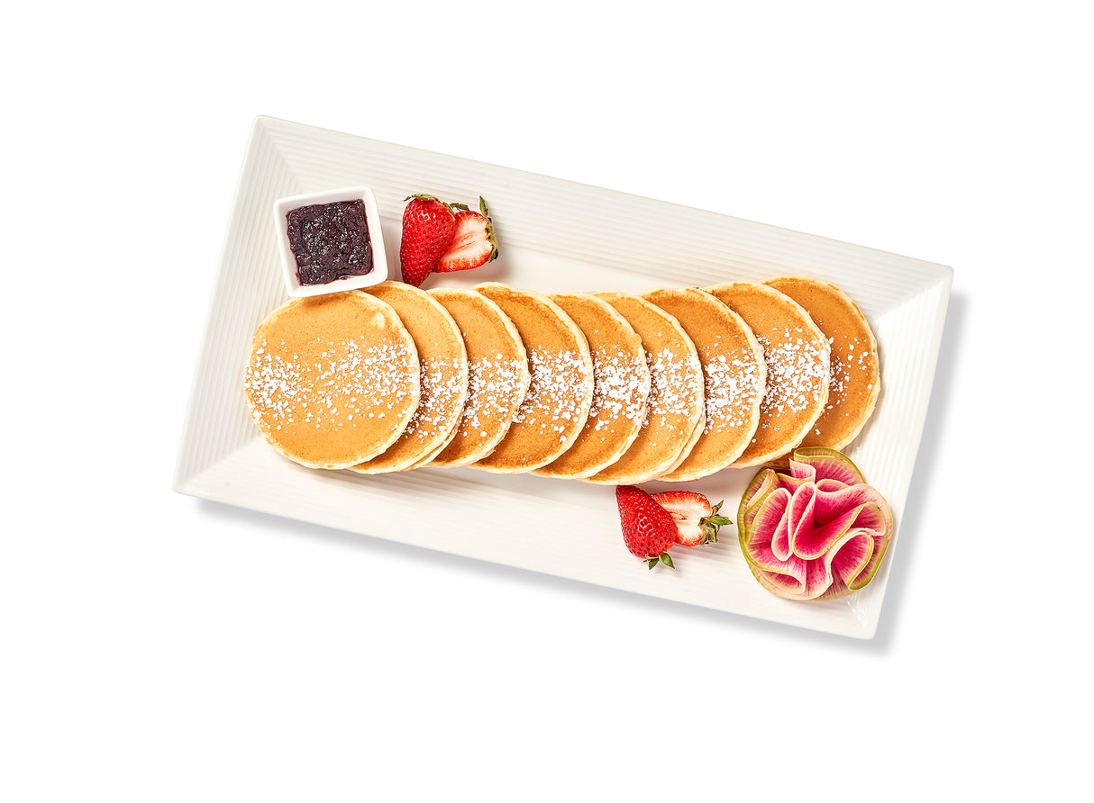 Buttermilk Pancakes on a plate with strawberries and syrup.