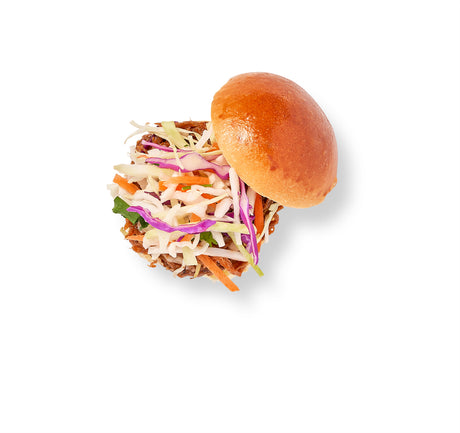 A BBQ Beef Brisket sandwich with Asian slaw of shredded cabbage and carrots served on a glossy mini brioche bun, viewed from above on a white background.