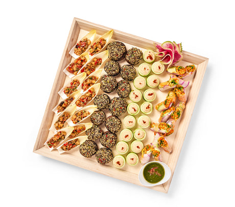 A Gluten Free & Vegan Party Platter with a variety of food on it, including hummus and cucumber cups.