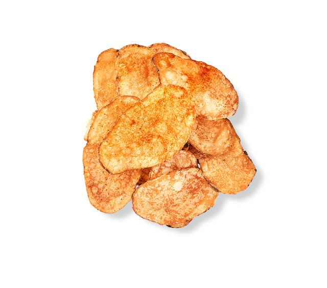 A pile of individual bags of homemade chips dusted with Old Bay seasoning on a white background.