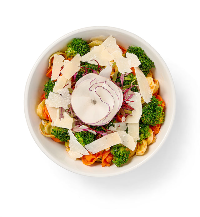 A bowl of Tortellini Pasta Salad with roasted broccoli and onions.