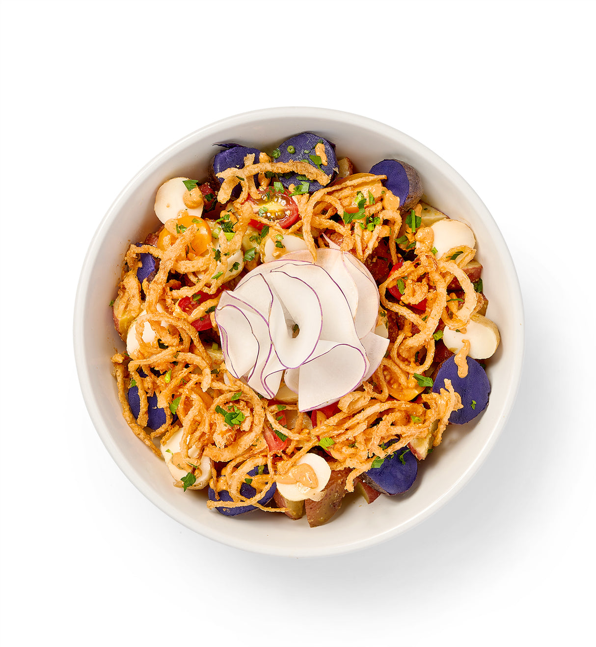 A bowl filled with Chipotle Roasted Potato Salad and vegetables garnished with crispy onions.